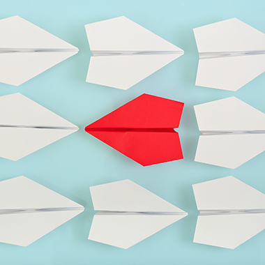 Rows of paper planes with one red plane