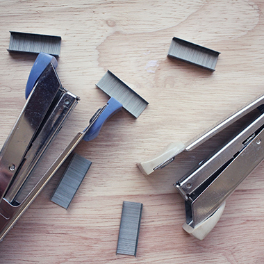 Stapler & Staples on wooden table flat lay view