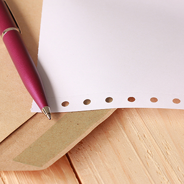Pen and paper on wood background