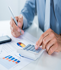 Man Working on Calculator with Financial Report on Desk