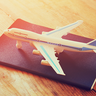 Toy Airplane & Passport on Wooden Table