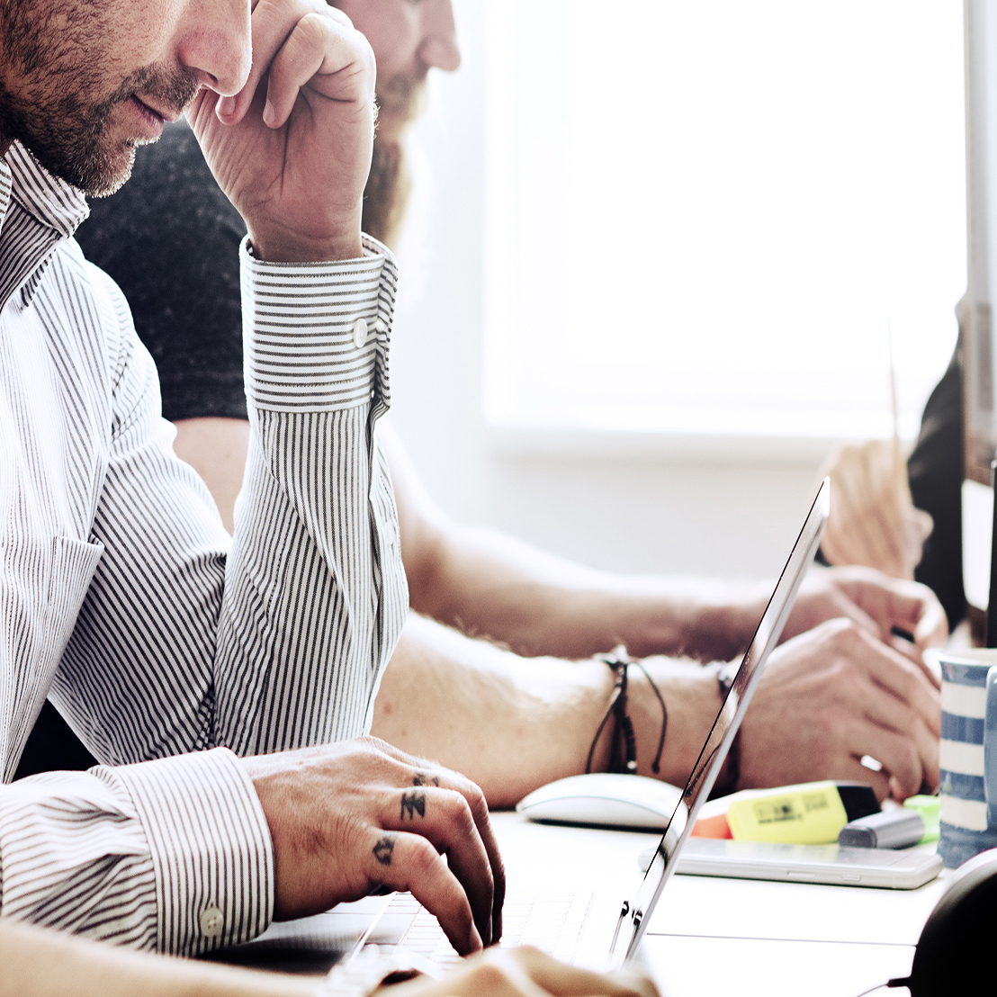 People sitting around a computer working professionally