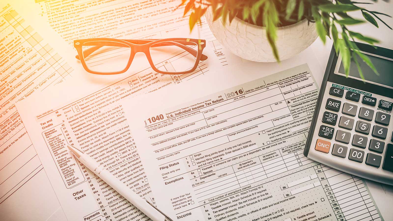 Tax forms with office supplies and plan, shining in sunlight
