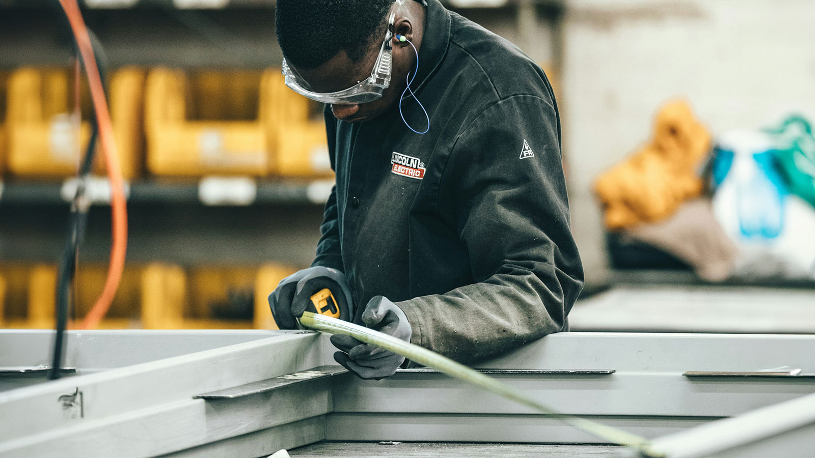 Employee in a manufacturing plant measuring