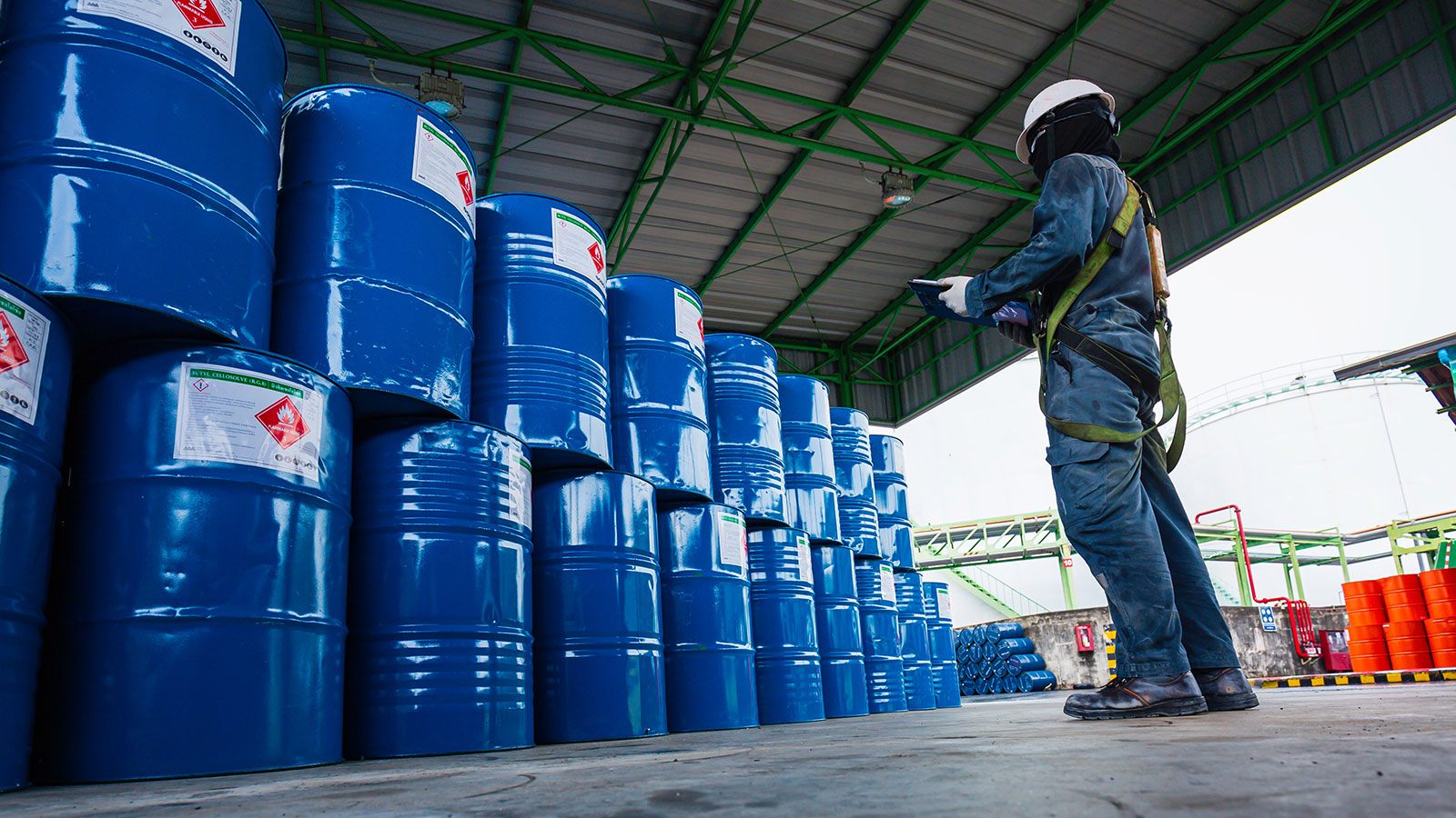 Male worker inspection record drum oil stock barrels blue vertical or chemical