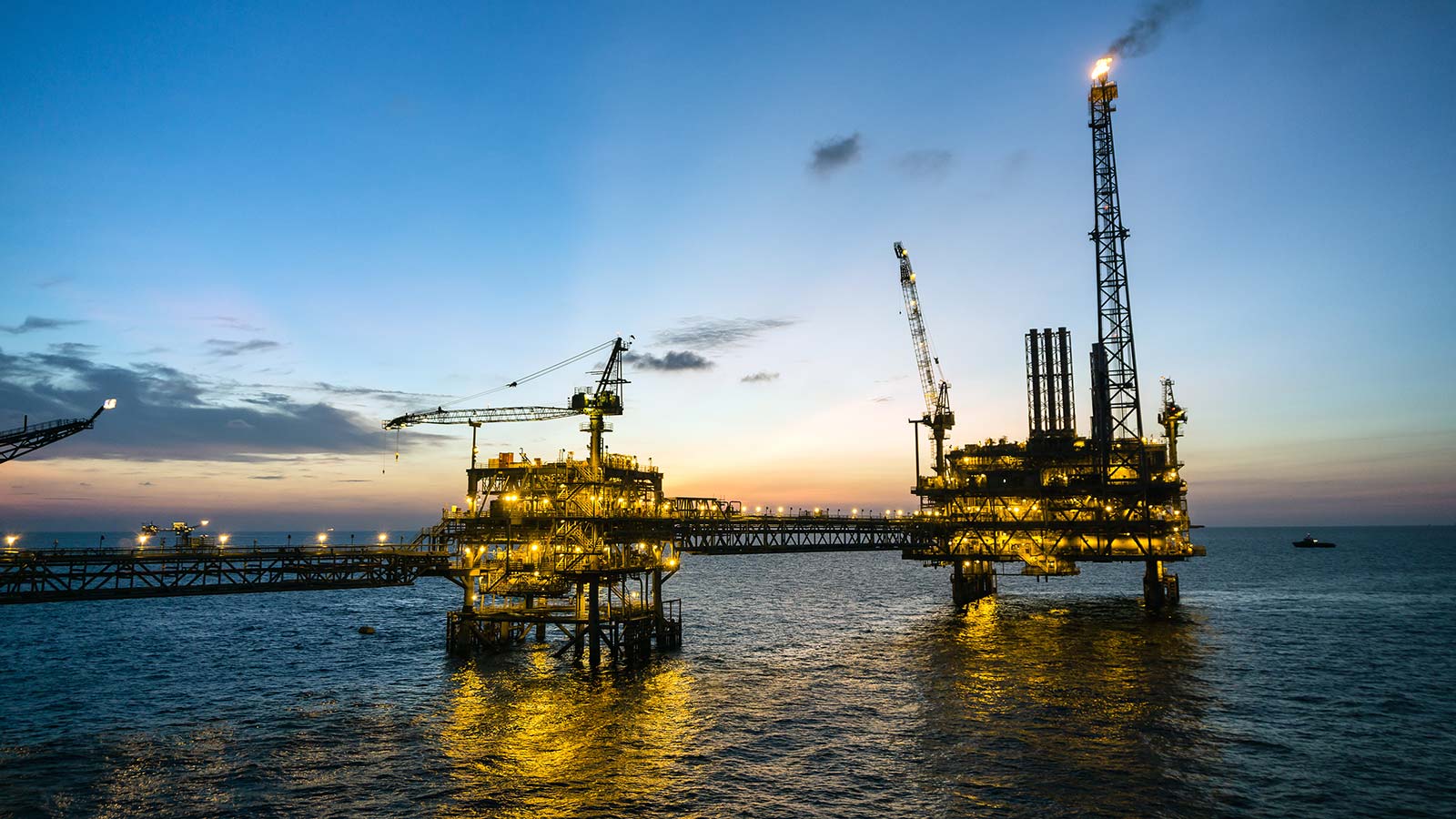 Silhouette of oil production platform during sunset