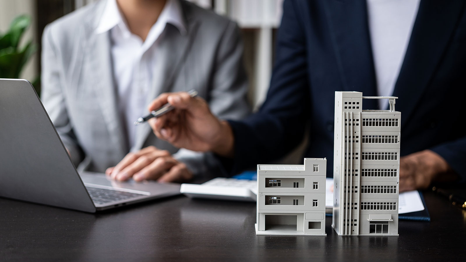 The real estate agent discusses the terms of the home purchase agreement and asks the client to sign paperwork to contract and deliver the home.