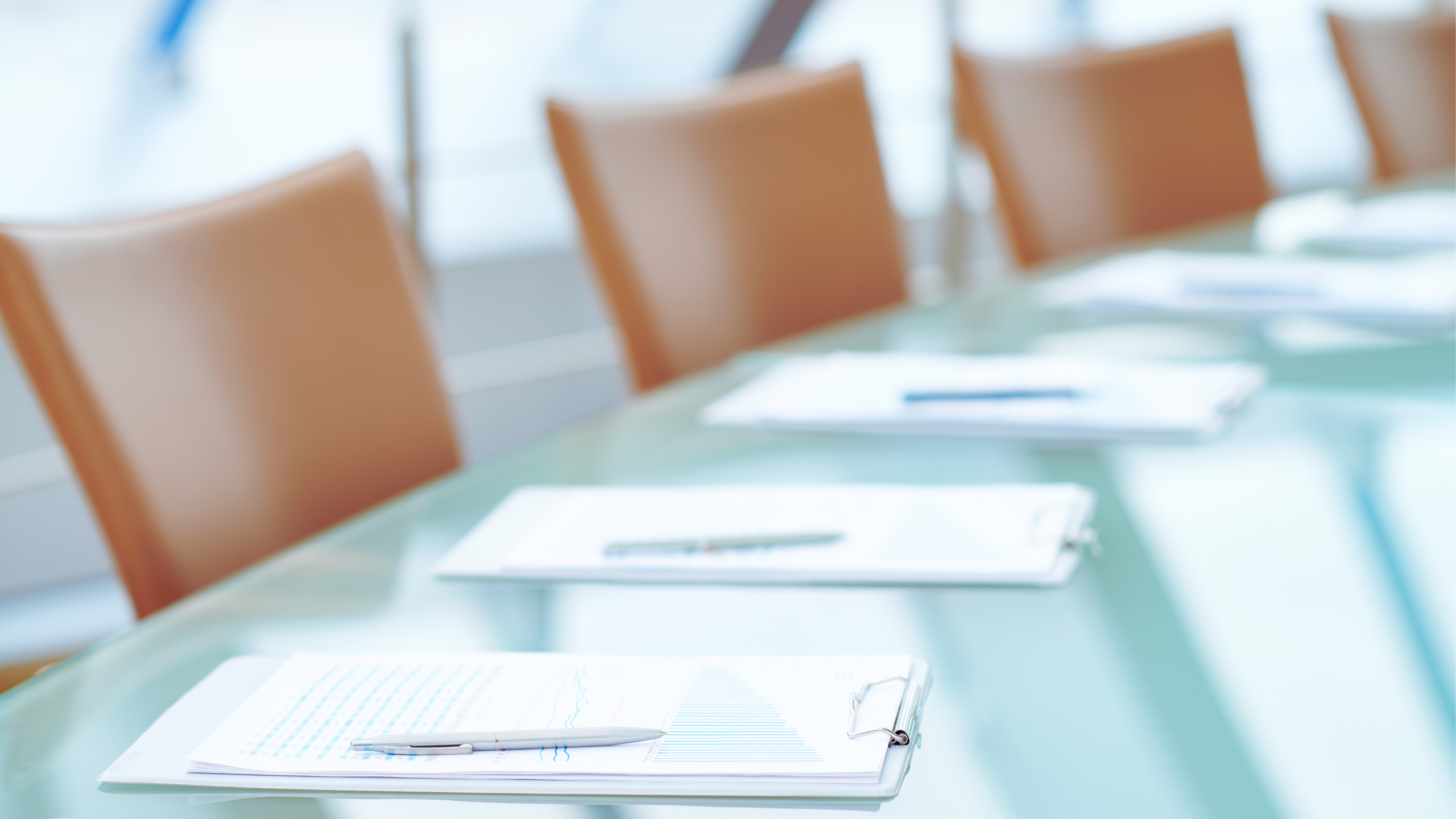 Meeting table with multiple desk chairs and business pamphlets.