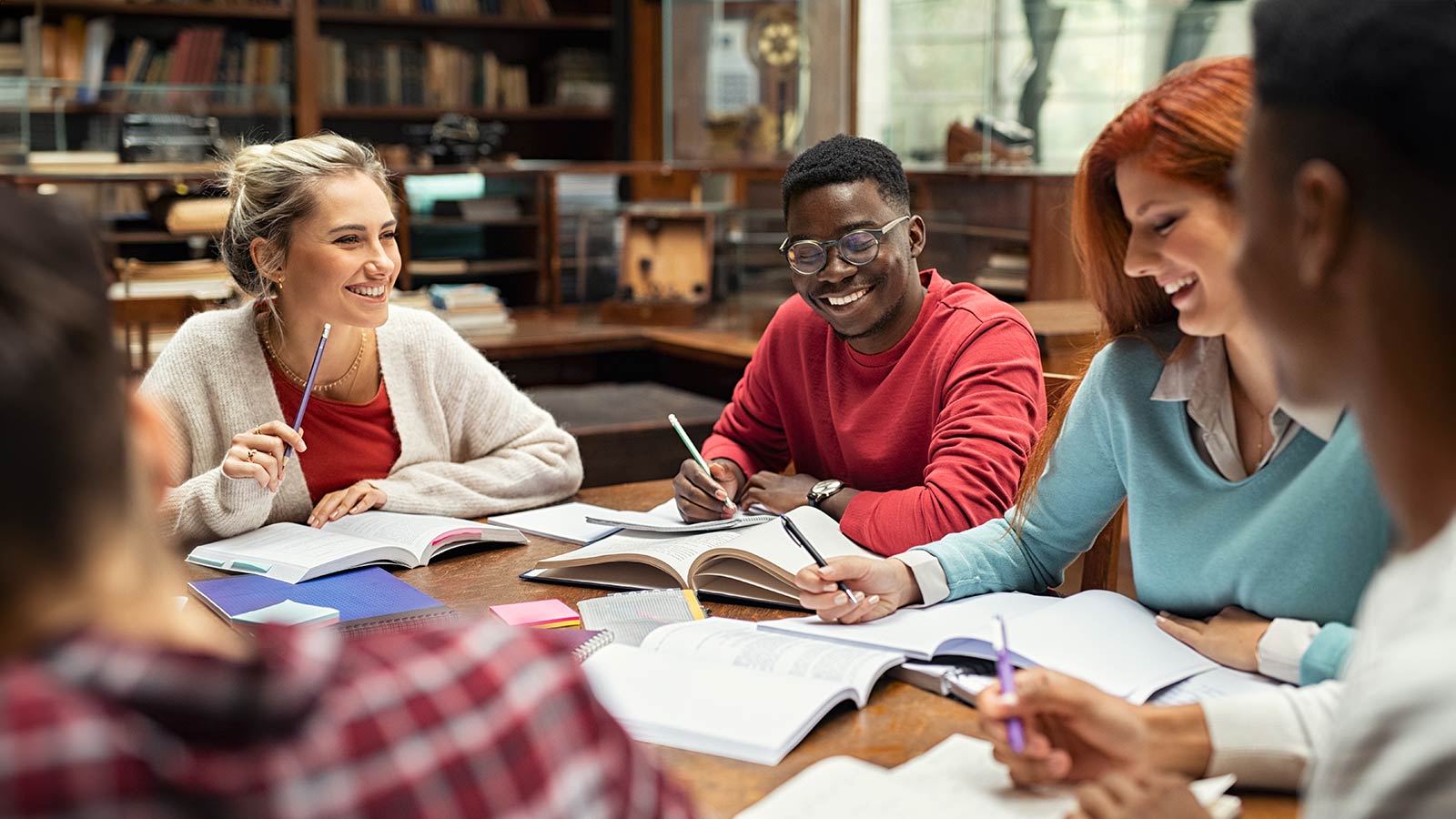 Happy college students studying together