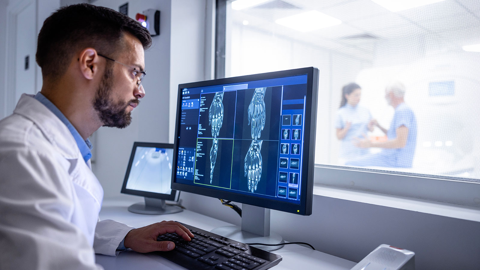 MRI diagnostic center control room and neurologist examining patient X-ray images on large display