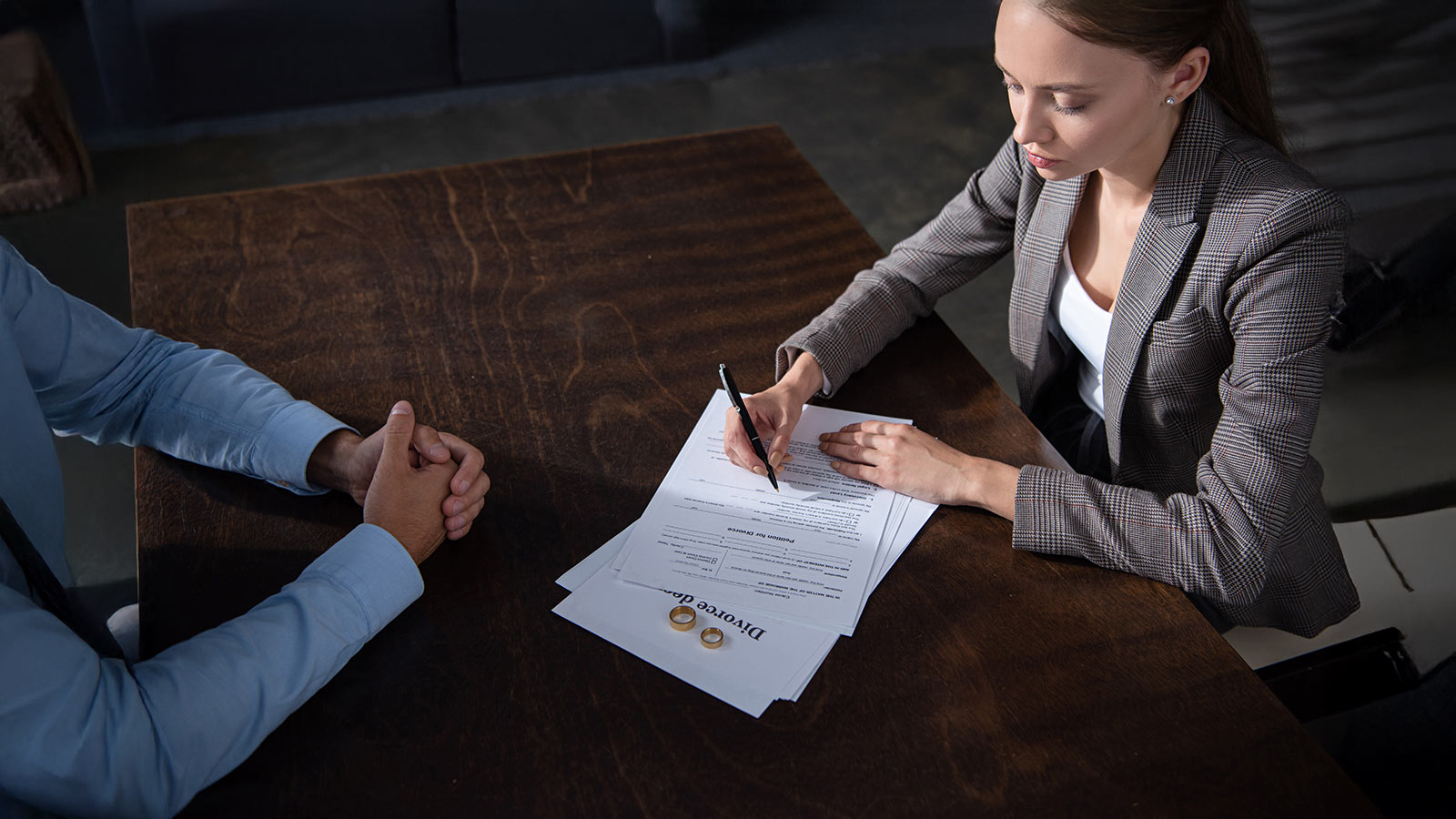 partial view of couple at table with divorce documents