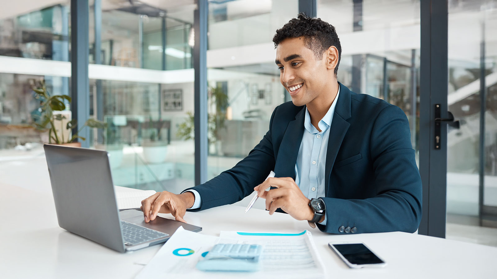 Planning businessmen that is happy with his laptop at a desk