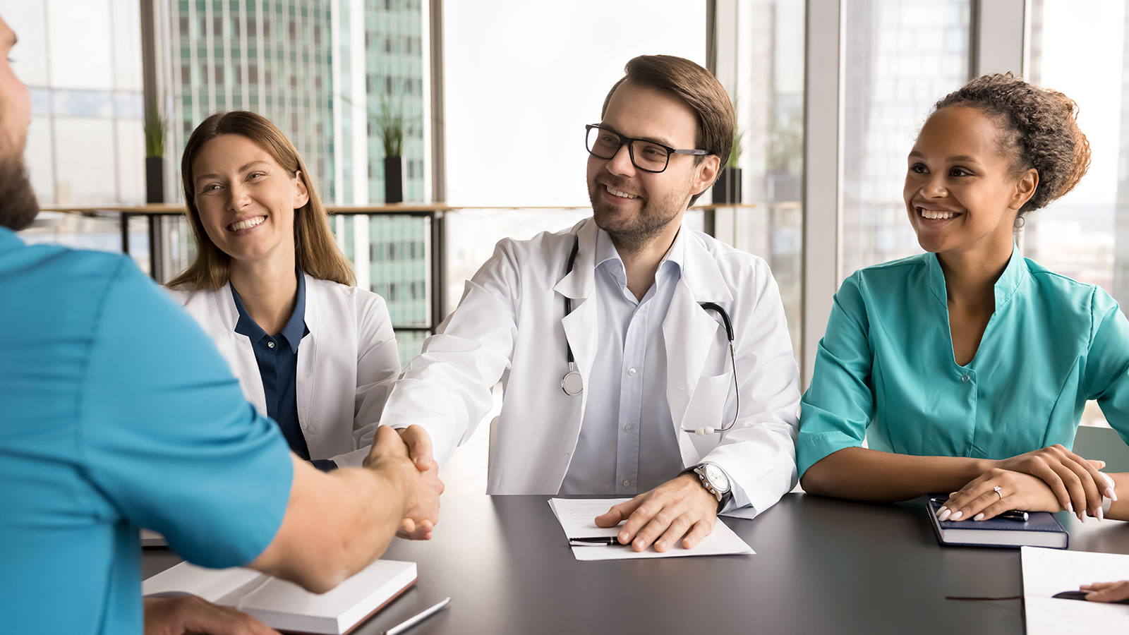 Group of medical professionals, healthcare workers gather in conference room in modern skyscraper office