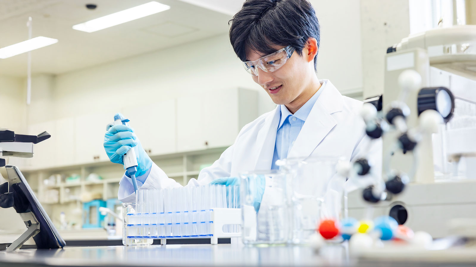 A man in a white coat conducting an experiment in a laboratory
