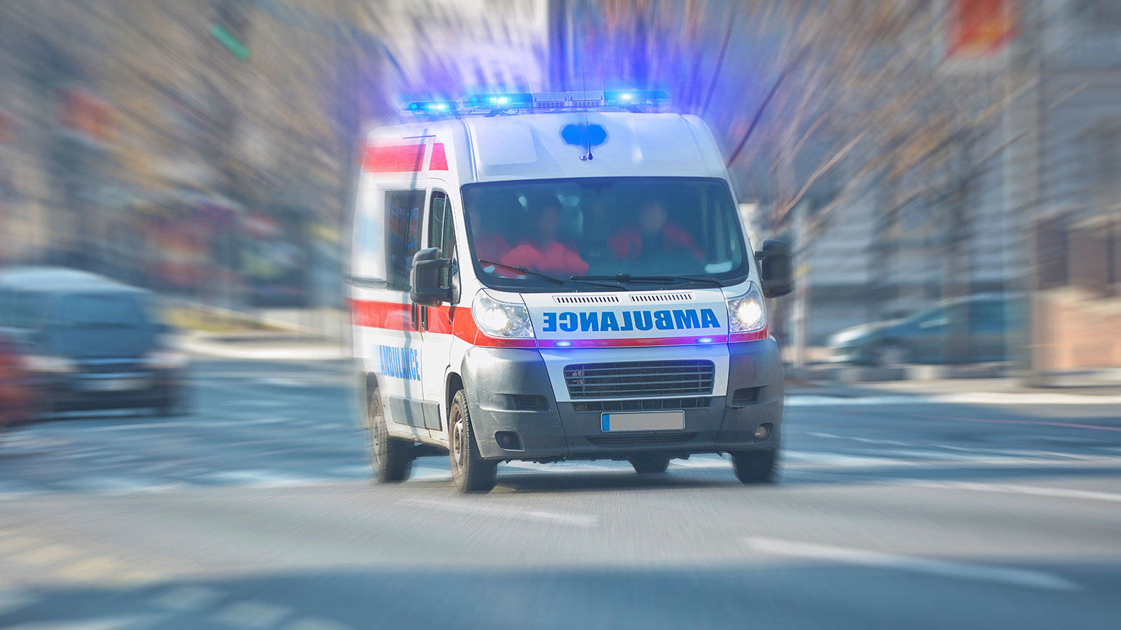 Paramedic 911 ambulance car running fast through the big city.