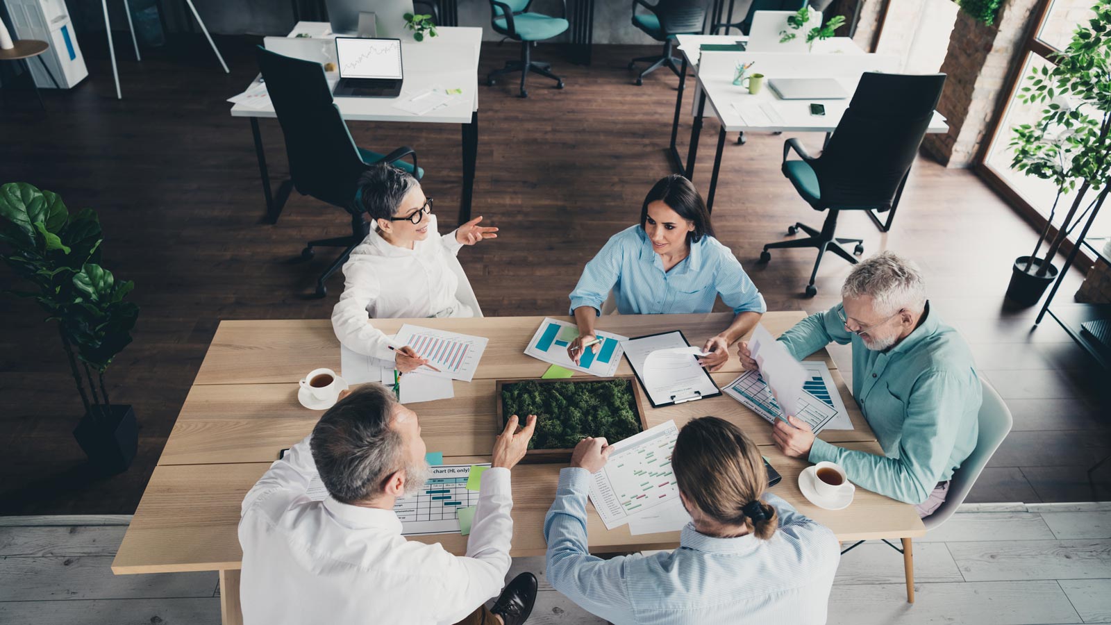 Photo high view of teamwork startup partners people sit table work together