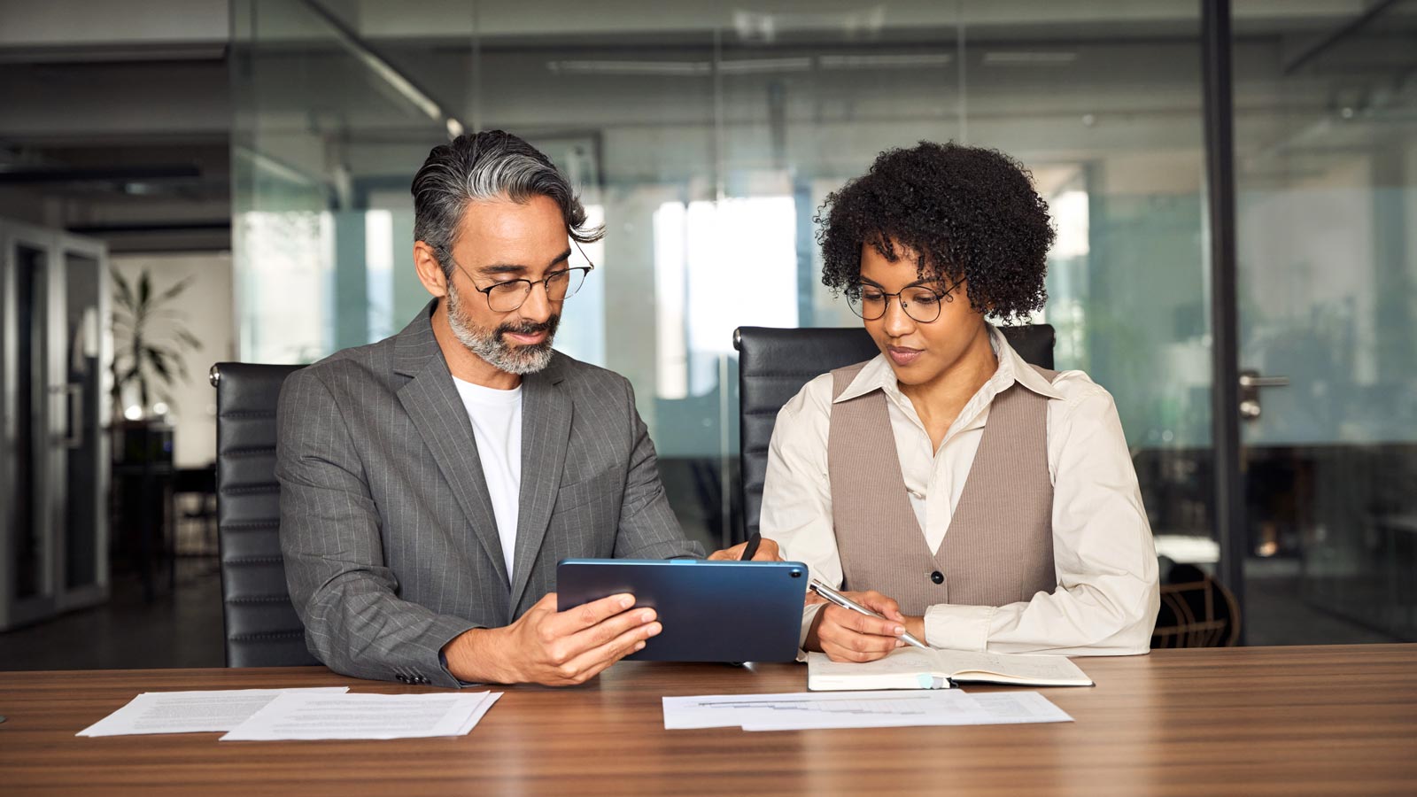 Two busy happy professional business team people working in office using digital tablet