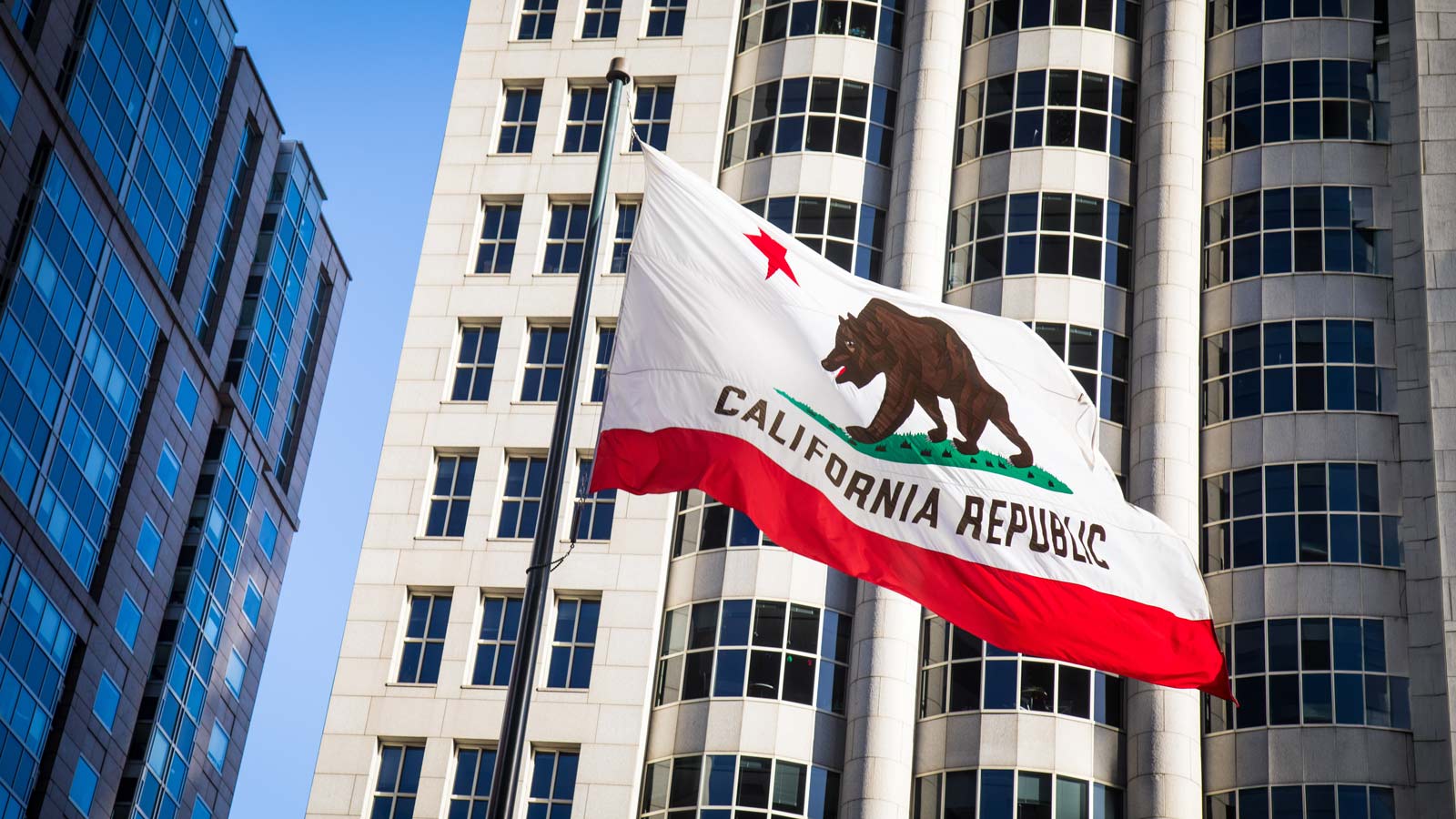 Low-angle shot of the California state flag winding in Downtown, San Francisco