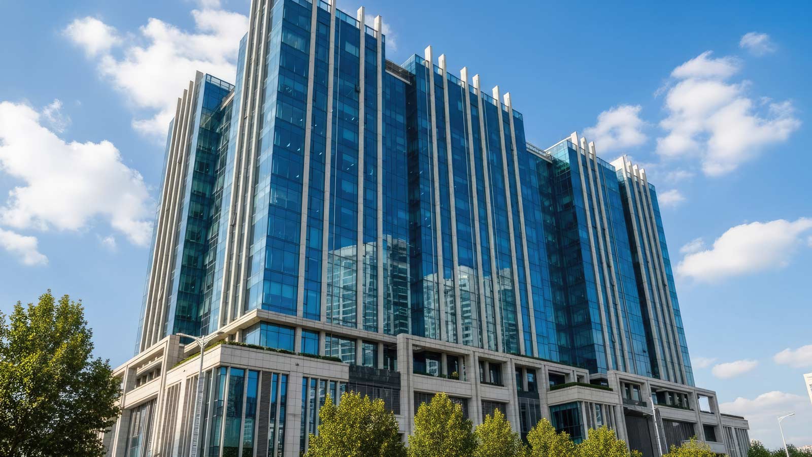 Modern glass skyscraper with reflective windows under blue sky