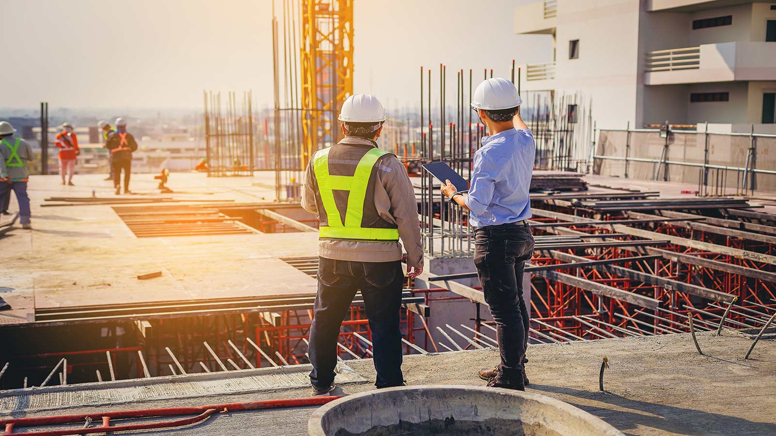 Structural engineer and foreman worker with touch pad discuss